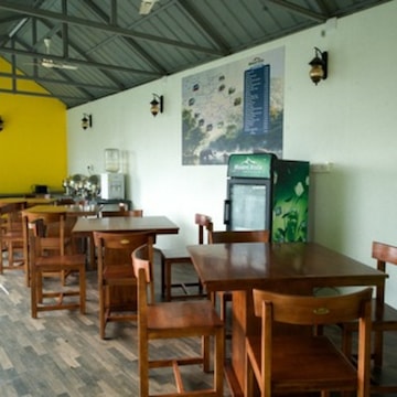 Indoor Dining Area with Wooden Tables and Yellow Accent Wall