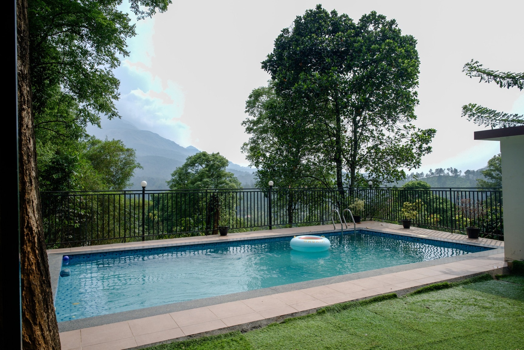 Outdoor Swimming Pool with Lush Greenery and Mountain View