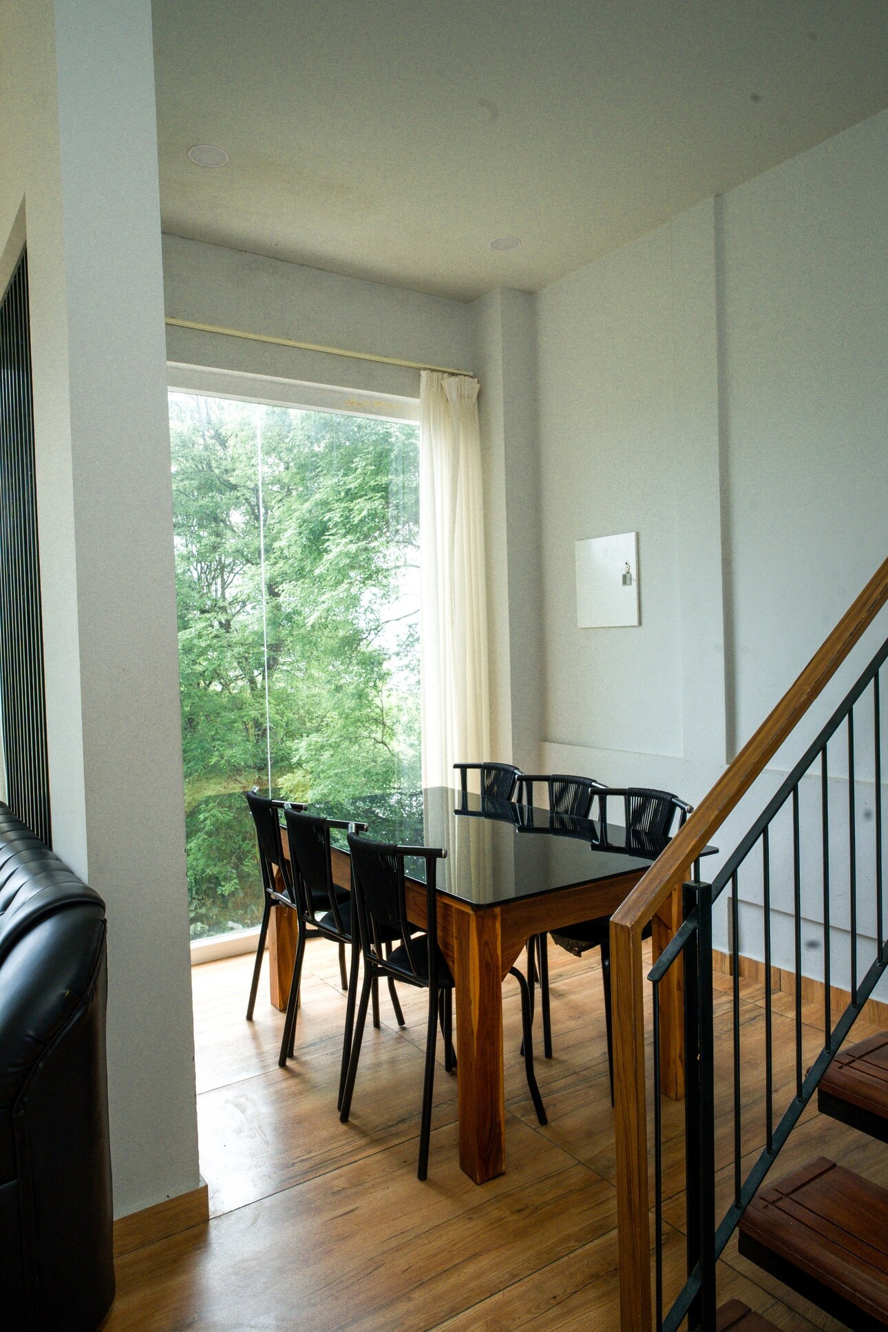 Indoor Dining Area with Full-Height Window and Tree View