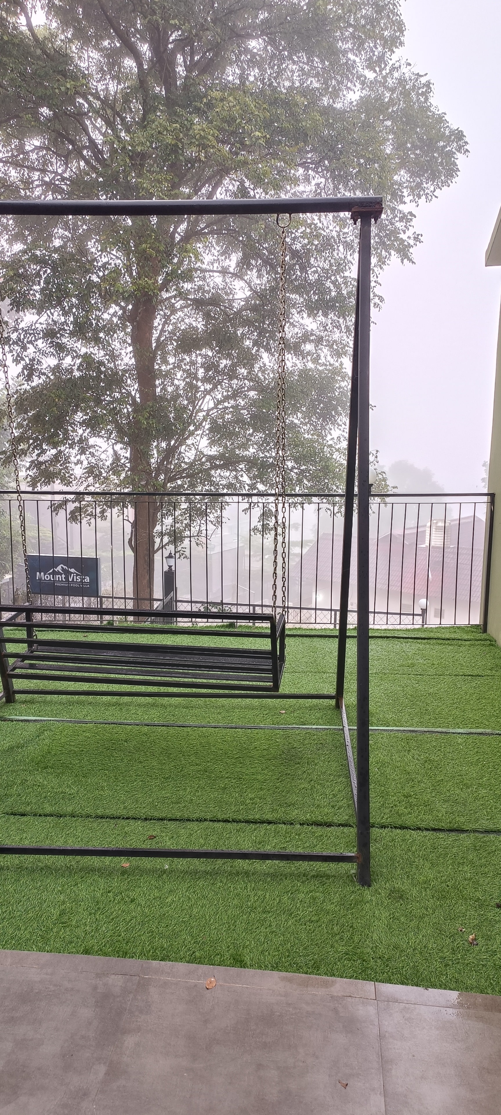 Outdoor Swing on Faux Grass in Misty Weather